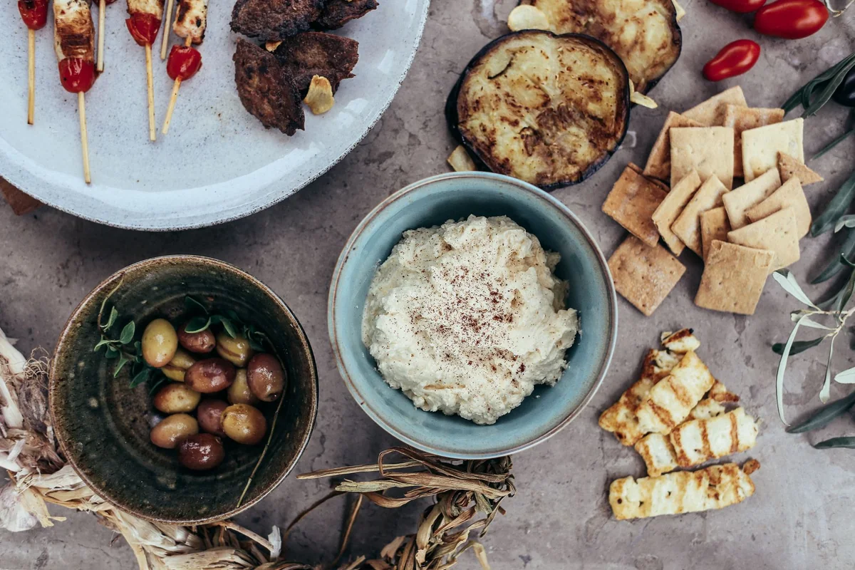 Přehled grilovaných špízů, oliv, dipu a grilované zeleniny — typické řecké tavernové jídlo, nikoli skutečné podávané tříchodové menu